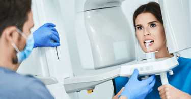 Dentist performing an xray on a woman.